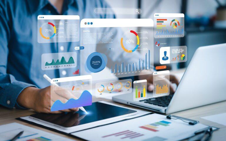 Un professionnel utilisant un ordinateur portable avec des graphiques et des tableaux de bord virtuels, illustrant la prise de décisions basées sur les données et l’analyse des performances.